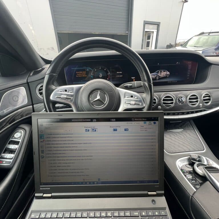 Laptop cu software de diagnoză Mercedes rulând un test rapid al modulelor, pe scaunul unui S-Class